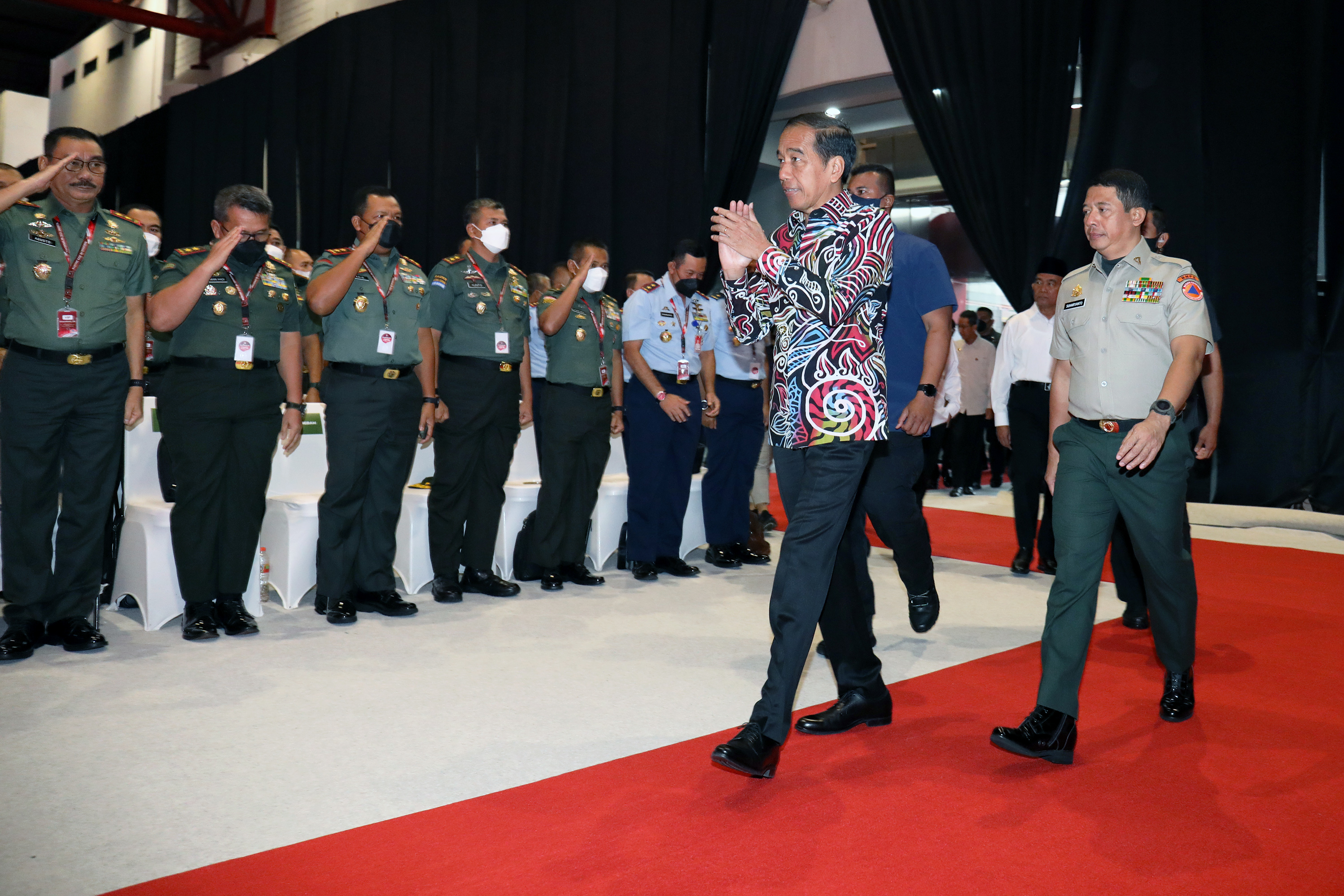Presiden Joko Widodo (mengenakan batik) didampingi Kepala BNPB Suharyanto (kanan) menyapa hadirin saat tiba di ruang Rapat Koordinasi Nasional (Rakornas) Penanggulangan Bencana (PB) Badan Nasional Penanggulangan Bencana (BNPB) tahun 2023 yang diselenggarakan di Jakarta International Expo (JiExpo) Kemayoran, Jakarta Pusat